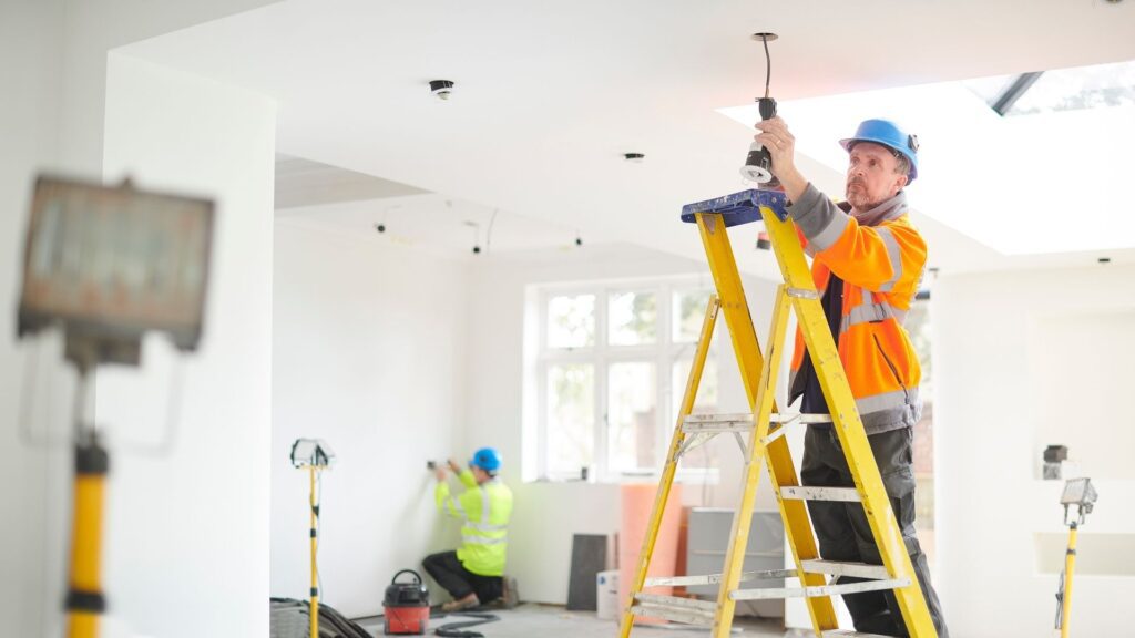 man installing light after an EICR report was done in Norfolk by Electric 11