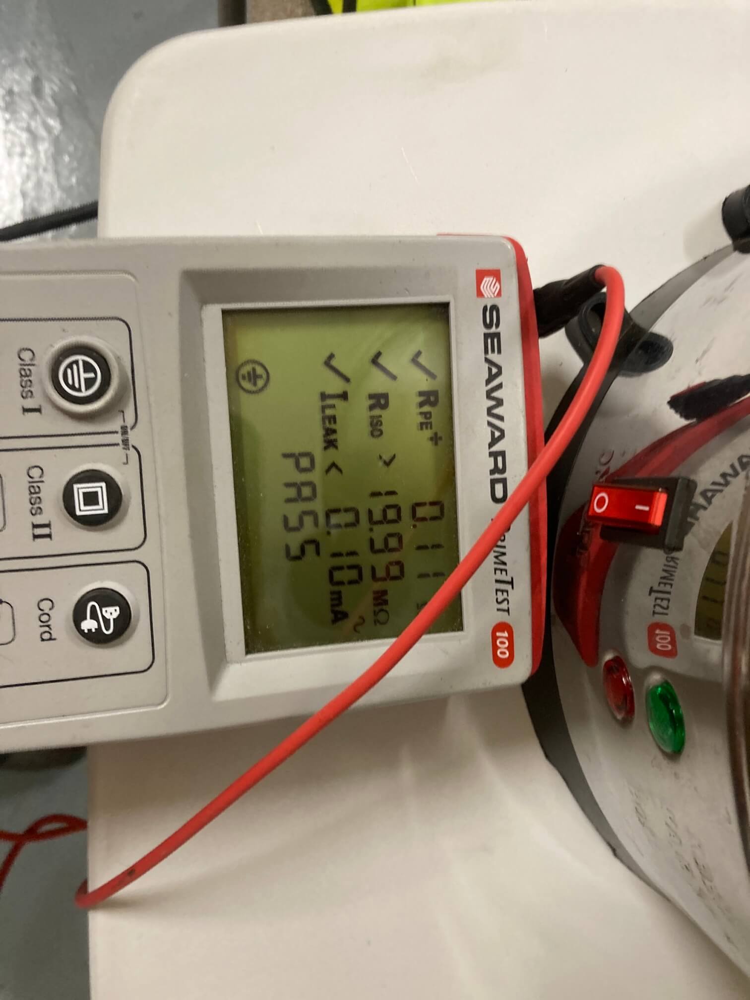 PAT tester displaying a pass result beside commercial catering equipment