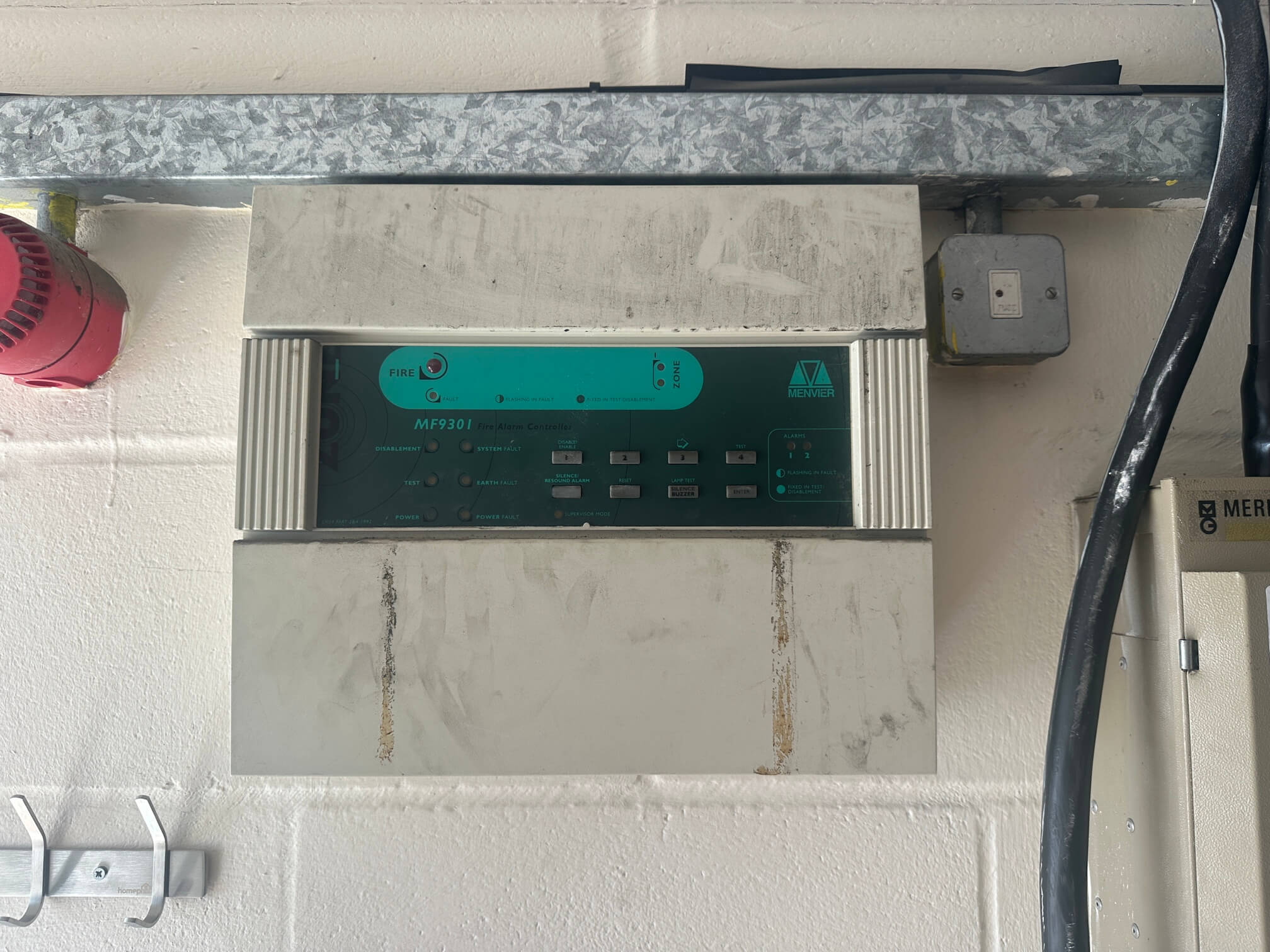 Existing Menvier fire alarm control panel in a workshop