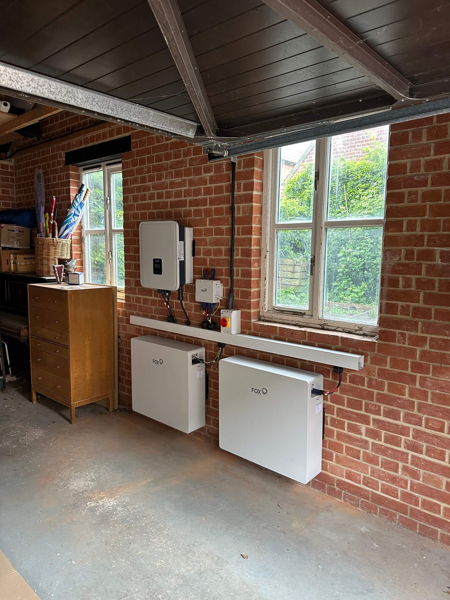 Two Fox ESS EP12 batteries and inverter mounted on a brick wall in Norwich