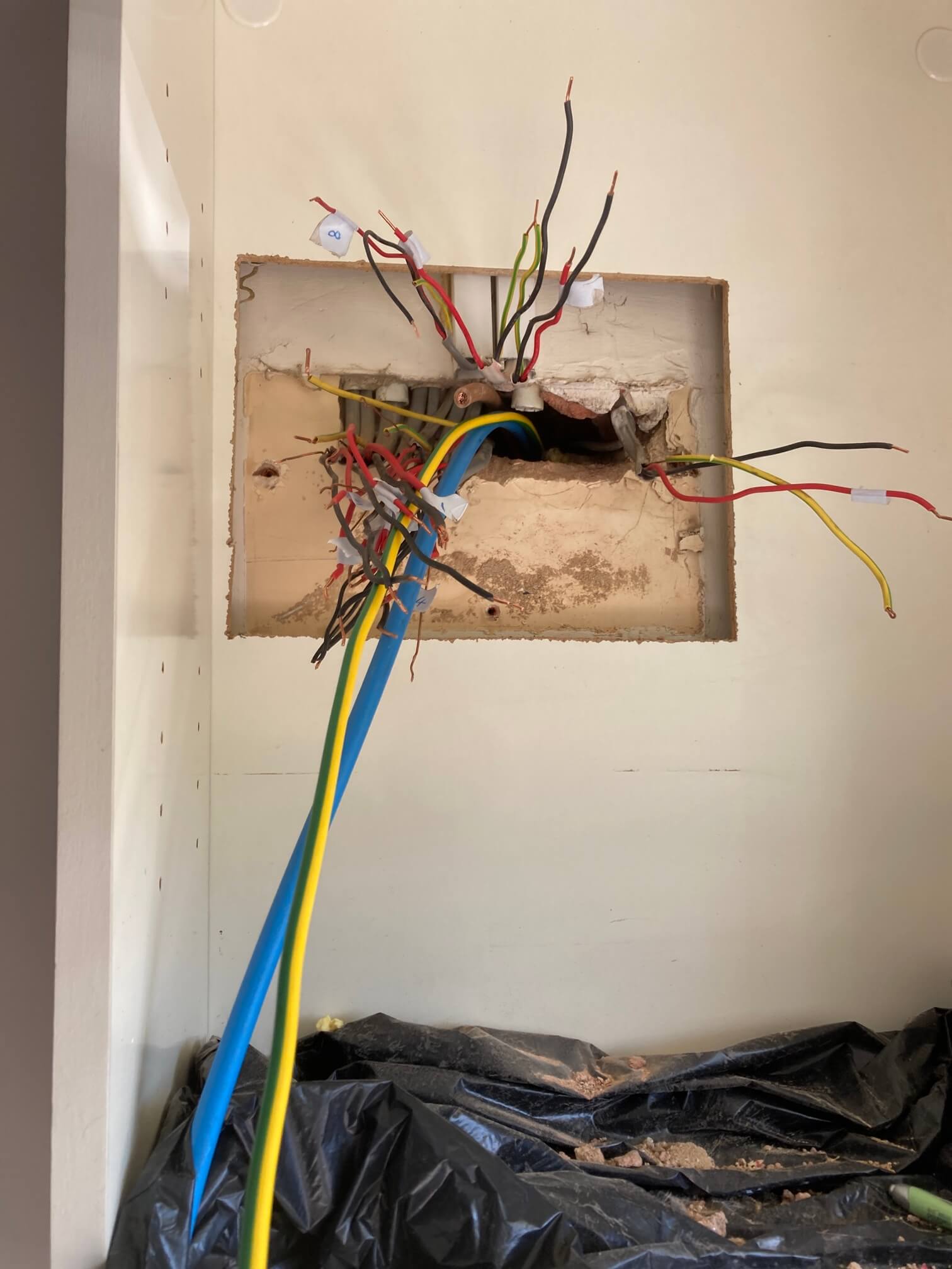 Old consumer unit wiring exposed before replacement at a Wicklewood home