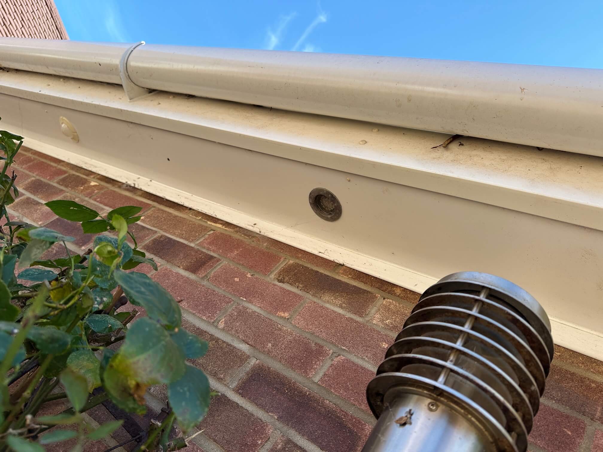 Soffit opening and cylindrical wall light below roof guttering