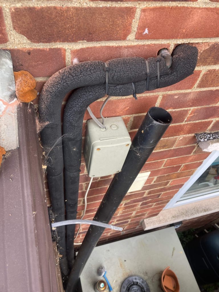 Cables routed along a brick wall toward an external electrical enclosure