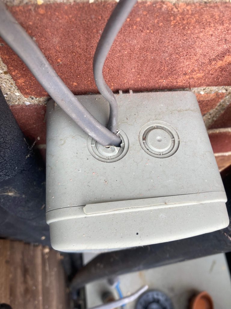 Close-up of an outdoor electrical enclosure with cable entering from above