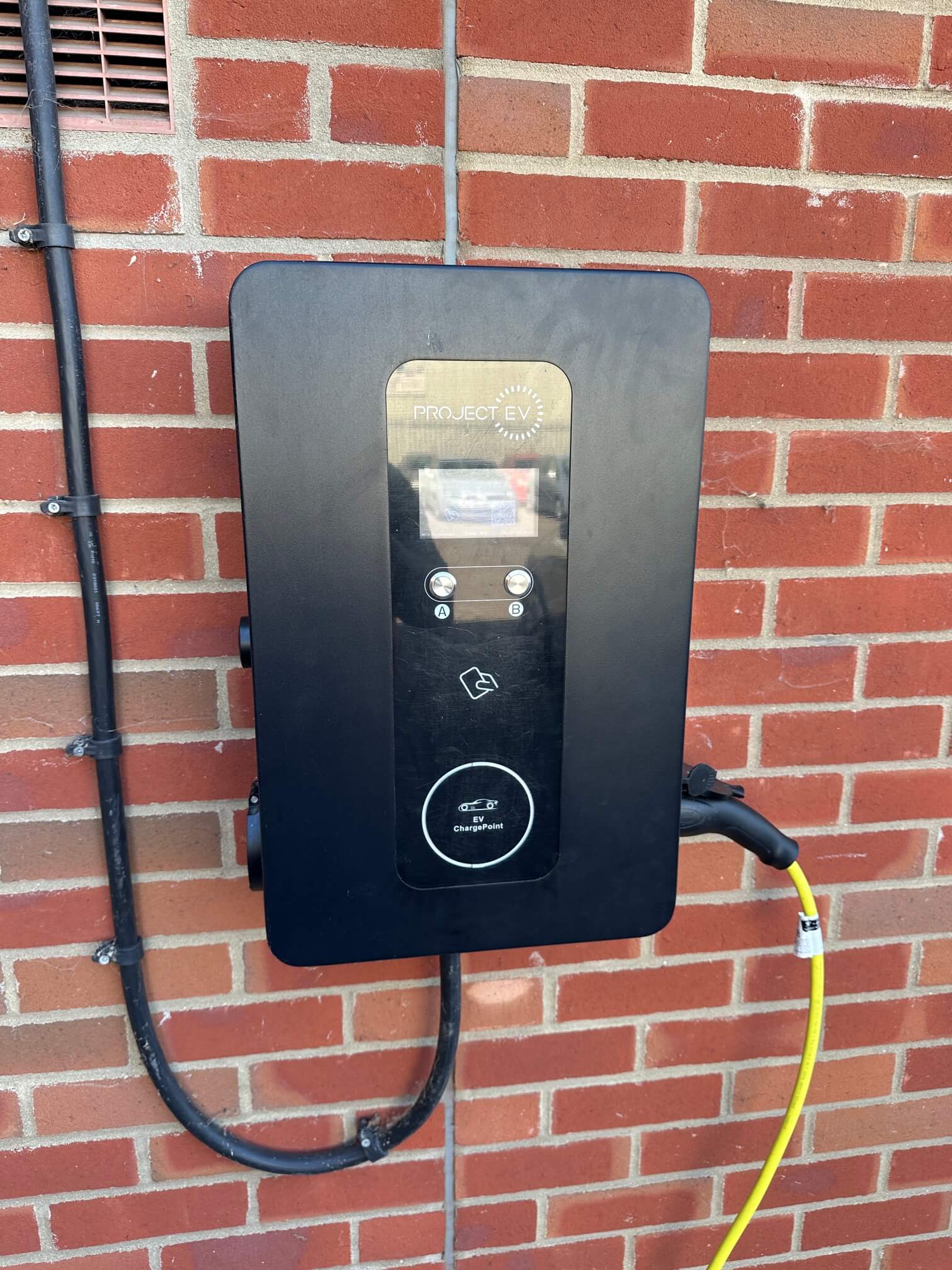 Front of a wall-mounted EV charge point with two connector positions