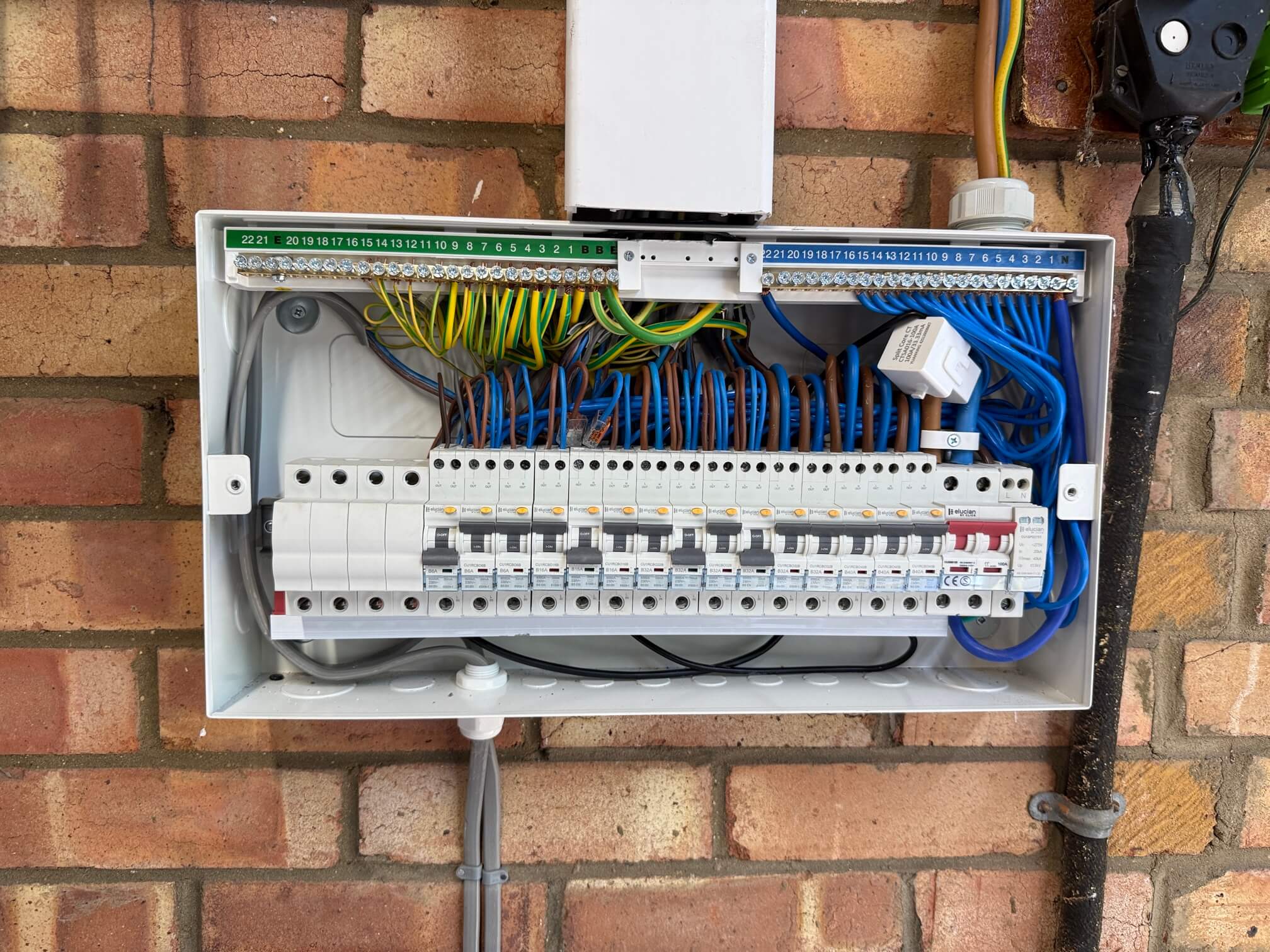 Replacement consumer unit with its front cover removed, showing circuit devices and internal wiring.