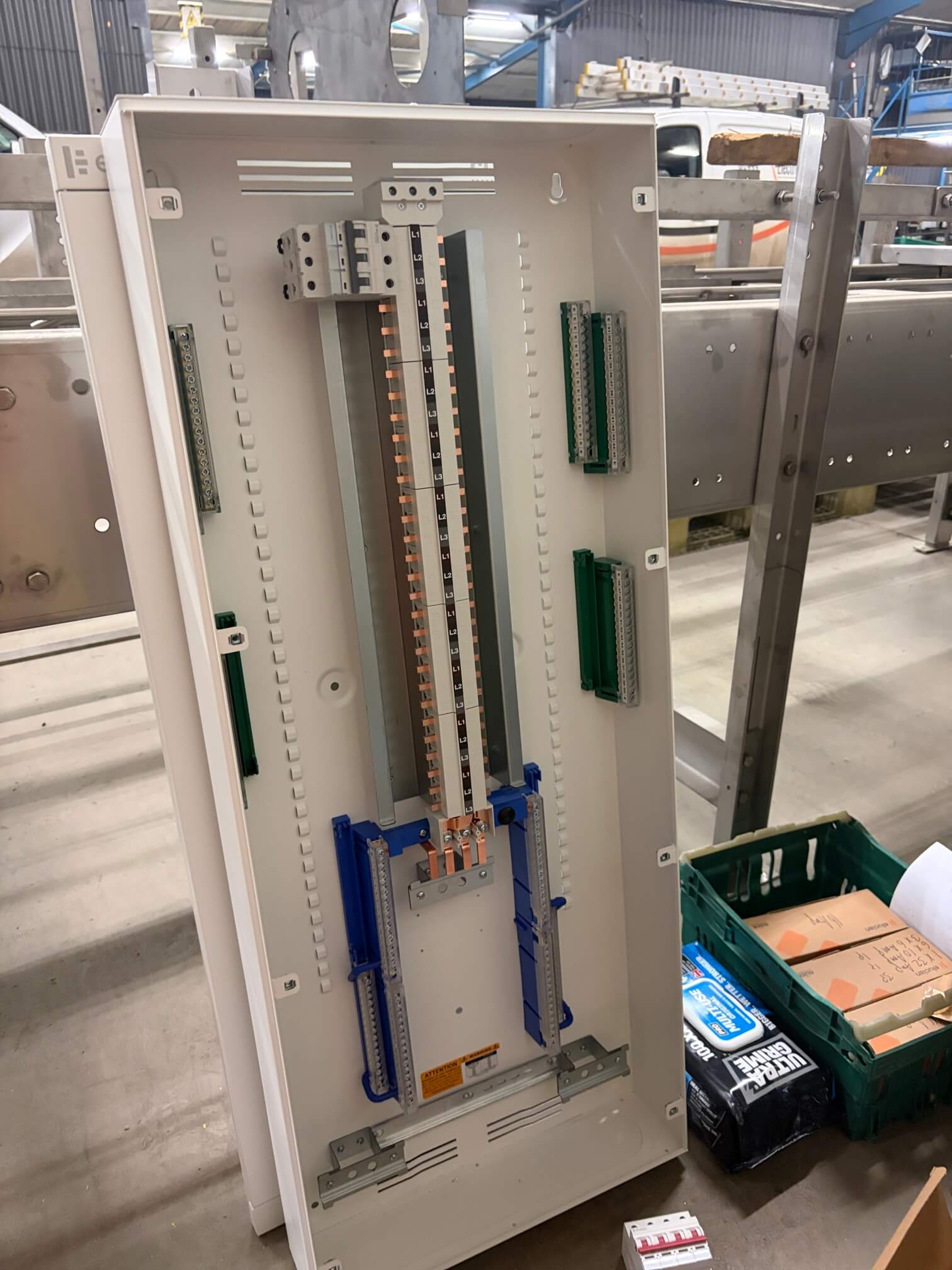 Open distribution board enclosure with phase-marked busbar and terminal bars before circuit connections.