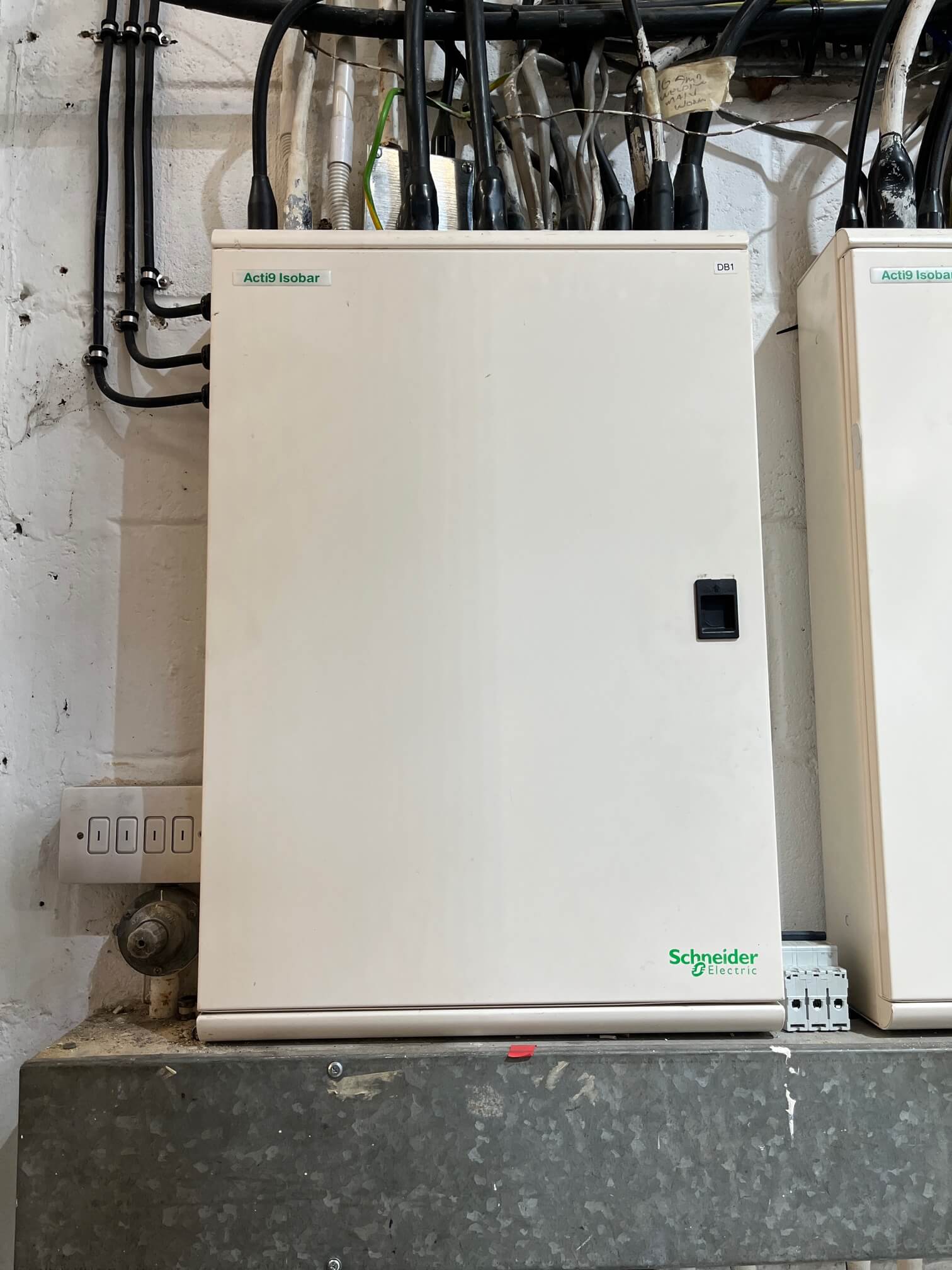 Closed Schneider Electric distribution board labelled DB1 beside a second board.